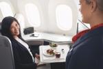 Smiling passenger interacting with a flight attendant in Air Canada Signature Class cabin